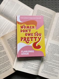 a book sitting on top of an open book with the title women don't own you pretty