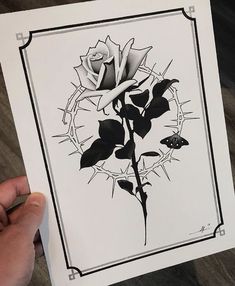 a person holding up a drawing of a rose