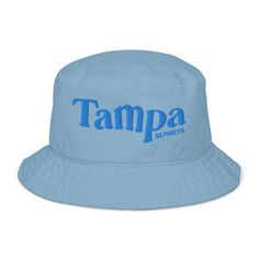 Elevate your casual style and make an eco-friendly choice with our chic and versatile Tan Bucket Hat, featuring the vibrant blue embroidered text "Tampa Sunsets." This 100% organic cotton twill hat combines sustainability with fashion, making it a favorite addition to any wardrobe thanks to its breathable material and clean look. Perfect for sunny days at the beach, strolling through the city, or adding a touch of effortless cool to any outfit. Key Features: Stylish Design: This tan bucket hat e Adjustable Cotton Hats With Logo Print, Adjustable Cotton Hat With Logo Print, Summer Cotton Hats With Logo Print, Summer Cotton Hat With Logo Print, Trendy Cotton Hat With Logo Print, Cotton Bucket Hat With Letter Print, Casual Summer Hats With Logo Print, Tan Bucket Hat, Embroidered Text