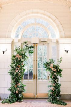 an arched doorway with flowers and greenery at the entrance to a wedding ceremony venue