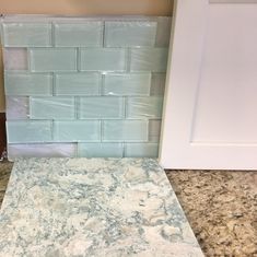 a blue and white marble counter top next to a door in a room with beige walls