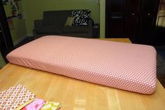 a pink pillow sitting on top of a wooden table