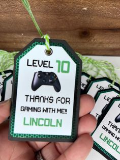 a hand holding a game controller tag that says level 10 thanks for gaming with me lincoln