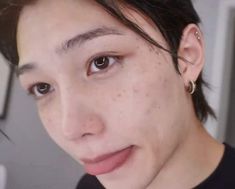 a close up of a person with freckles on her face and black shirt