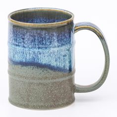 a blue and gray coffee mug sitting on top of a table