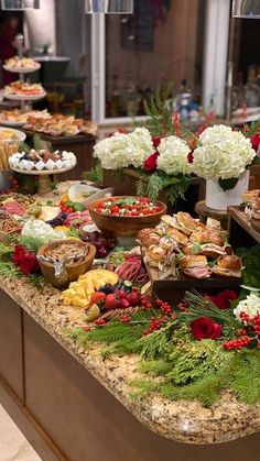 a buffet table filled with lots of food and flowers on it's counter top