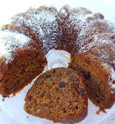 a bundt cake is cut into slices on a white plate with powdered sugar