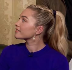 a woman with blonde hair sitting on a couch in front of a man wearing a blue shirt