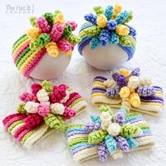 four crocheted flowers are placed next to each other on a white tablecloth