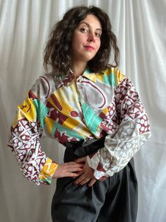 "90s Louis FERAUD viscose blouse with abstract print.  Viscose with bright abstract print.  Hidden fastening. Enamelled button under the collar, same buttons on the cuffs.  SIZE. Size on the tag D42, US12, US16, F44. Large.  Length 60 cm Shoulder to shoulder 48 cm  Bust 116 cm  Sleeve length 54 cm  For reference: model usually wears size Small, D36, US6.  Hight 1.55 cm or 5.1 feet  Bust 90 cm | 35\"  Waist 74 cm | 29\" Hips 94 cm | 37\" CONDITION. Perfect condition." Retro Collared Blouse With Graphic Print, Retro Abstract Print Tops For Fall, Retro Multicolor Print Blouse For Fall, Collared Patterned Tops With Abstract Print, Retro Multicolor Tops With Abstract Print, Collared Top With Abstract Print, Patterned Collared Top With Abstract Print, Retro Abstract Print Patterned Tops, Retro Long Sleeve Blouse With Vibrant Print