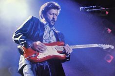 a man playing an electric guitar on stage