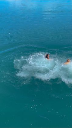 two people are swimming in the ocean together