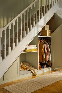 an open closet under the stairs in a house