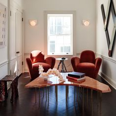 a living room with two chairs and a coffee table in it's center area