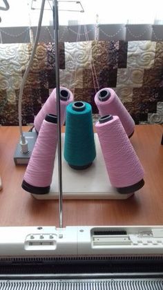 three spools of thread sitting on top of a sewing machine