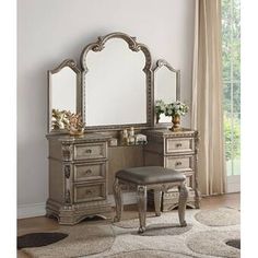 an antique vanity with mirror and stool in a living room or dining room, along with a rug on the floor