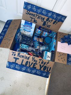 a cardboard box filled with items sitting on top of a floor