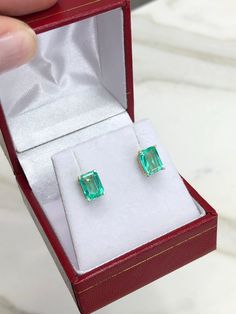 Featured here is a beautiful set of emerald cut Colombian emerald studs in fine 14K yellow gold. Displayed are medium-light green emeralds with excellent transparency, accented by a simple four-prong 14K gold mount, allowing for the emerald to be shown in full view. The earth mined, green Colombian emeralds have a desirable lush green color with excellent qualities. These earrings are ideal for everyday use and are the perfect accessory to any outfit. Total Carat Weight: 2.05cts Setting Style: F Rectangular Emerald Jewelry In Yellow Gold, Rectangular Emerald Yellow Gold Jewelry, Hallmarked Rectangular Emerald Jewelry, Formal Rectangular Earrings With May Birthstone, Baguette Cut Emerald Earrings As A Gift, Emerald Rectangular Earrings For May Birthstone, Formal Rectangular Fine Jewelry Gemstones, Classic Emerald Jewelry With Rectangular Stone, Rectangular Emerald Gemstone Earrings