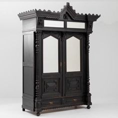 an ornate armoire with mirrored doors on the front and side panels in black wood