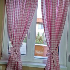 a window with pink gingham curtains in front of it