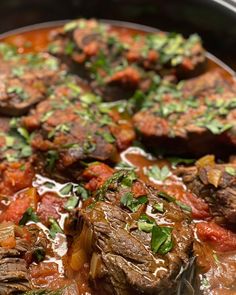 a pot filled with meat and vegetables covered in sauce