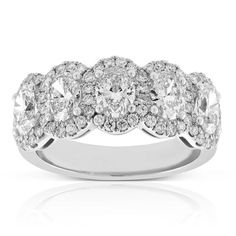 a three stone ring with diamonds on the sides and an oval center surrounded by smaller round stones