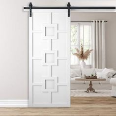 a living room with white furniture and an open sliding door that has squares on it