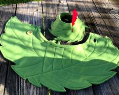 a green leaf shaped object sitting on top of a wooden table