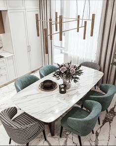 a marble dining table surrounded by blue chairs