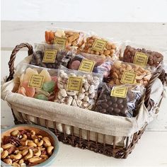 a basket filled with nuts next to a bowl of dried fruits and nuts on a table