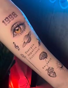 a person with a tattoo on their arm that has an eyeball and other symbols