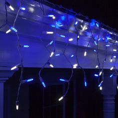 blue lights are hanging from the side of a house