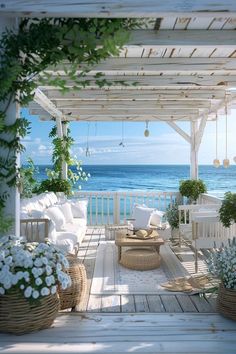 an outdoor living area with wicker furniture and flowers on the deck overlooking the ocean