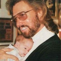 a man holding a baby in his arms