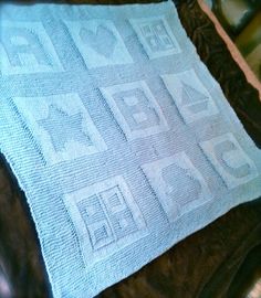 a close up of a blanket on a bed with the words love written across it