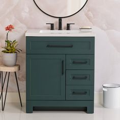 a bathroom vanity with a round mirror above it and a potted plant on the side