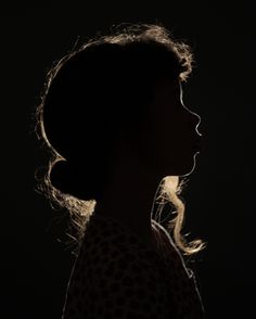 the silhouette of a woman's head against a black background