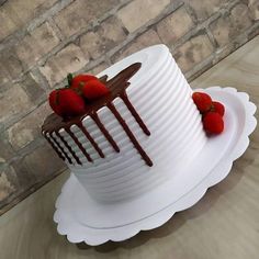 a white cake with chocolate icing and strawberries on top