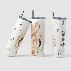 two tumblers with music notes and trebles on them, one has a straw in it