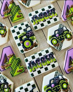 decorated cookies with monster trucks and checkered squares are displayed on a wooden table top