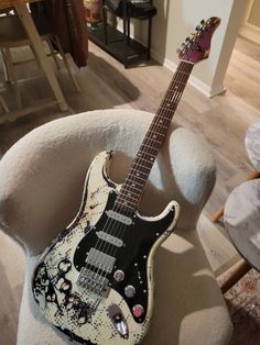 a black and white guitar sitting on top of a chair