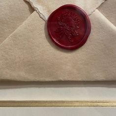 an envelope with a wax stamp on it and a red seal attached to the front