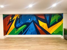 an empty room with a large colorful painting on the wall