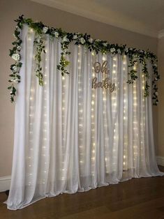 the curtains are decorated with flowers and greenery for a wedding ceremony or special occasion