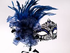 This a stunning masquerade metal laser cut mask with absolutely gorgeous rooster blue/ black feathers a black flower and a black stick and blue matching beautiful gems. If you wish this same style and design of mask to be without the stick please feel free to contact me I will be happy to make the change! In my store I have a large variety of masquerade metal laser cut mask for masquerade ball parties, I have lace machine embroidered masquerade mask I embroider too and if you wish for the thread Dark Blue Masquerade Mask, Mask For Masquerade Ball, Blue Masquerade Mask, Mask For Masquerade, Masquerade Ball Party, Metal Mask, Blue Feathers, Mask Masquerade, Mask Black