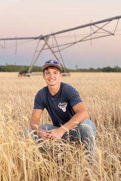 a man sitting in the middle of a wheat field