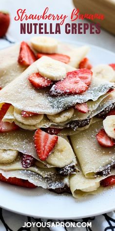 crepes with strawberries and powdered sugar are stacked on top of each other