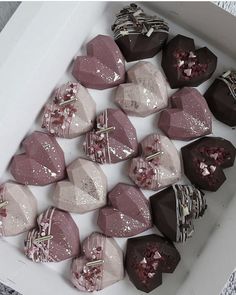 a box filled with lots of different types of heart shaped chocolates on top of each other