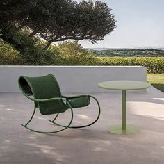 a green chair and table sitting on top of a patio