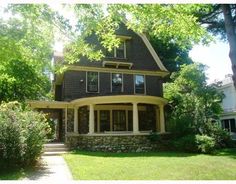 a large house sitting in the middle of a lush green yard with lots of trees